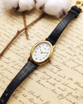 1990s Vintage Timex Oval Gold-Tone Dainty Watch – Black Leather Strap Edition